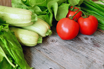 Zucchini and tomato on wood background