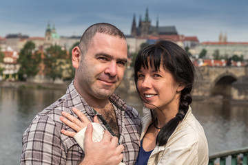 happy couple embracing in the background Charles Bridge in Prague