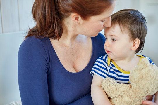 Mother and baby boy holding teddy bear