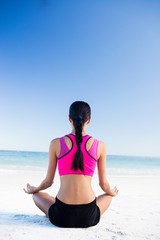Fototapeta na wymiar Woman doing yoga on the beach