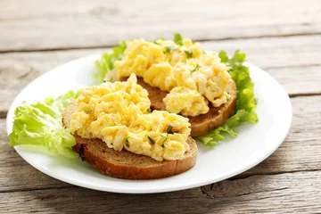 Photo sur Plexiglas Oeufs sur le plat Scrambled eggs with bread and vegetables on a grey wooden table