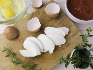 Tagliere con mozzarella,uova, pomodoro e origano per parmigiana