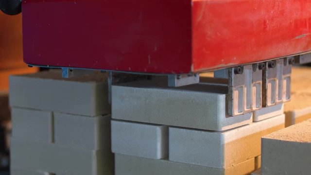 Industrial robot stacks the bricks on pallet