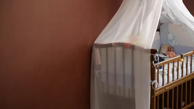 New born child in wooden co-sleeper crib, Infant sleeping