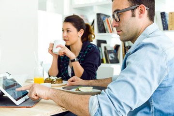 Young couple enjoying breakfast and working at home.