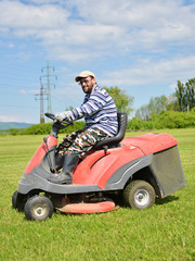 Fototapeta premium Smiling handicapped boy on lawn mower