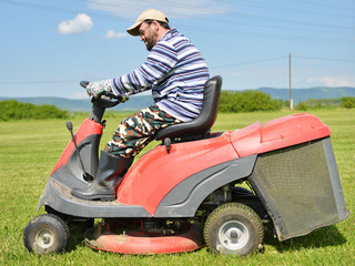 Smiling handicapped boy on lawn mower
