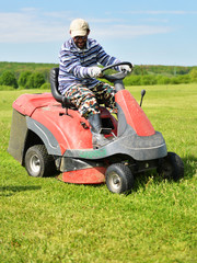 Smiling handicapped boy on lawn mower