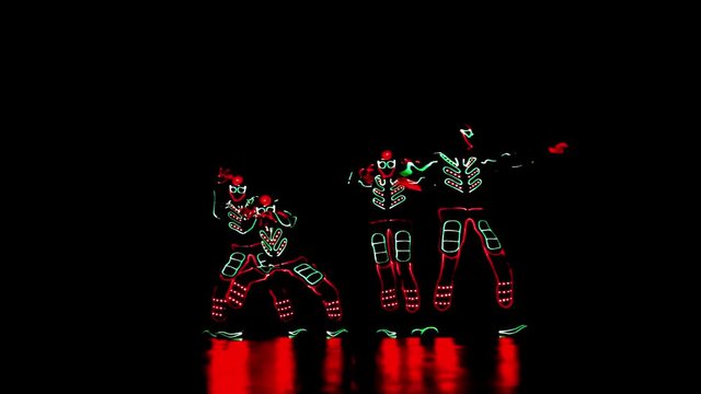 4 people dancing in costumes of LEDs