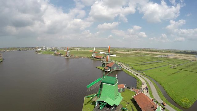 Zaanse Schans UAV flying over showing river Zaan and collection of well-preserved historic windmills and houses Zaanse Schans is one of the popular tourist attractions of the Netherlands 4k