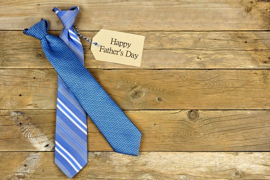 Happy Fathers Day gift tag with blue neckties on rustic wood background