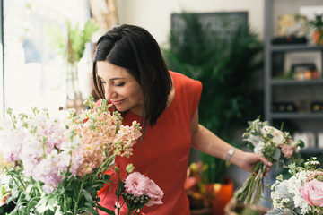 Florist smelling flowers in flower shop