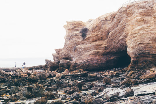 Distant view of people on rocky beach, Crystal Cove State Park, Laguna Beach, California, USA