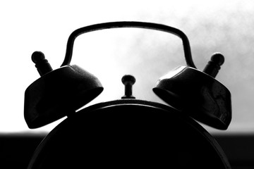  Detail of mechanical alarm clock foreground. Double dusty bell and backlighting.