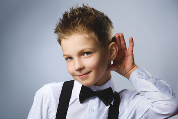 Curious smiling boy listens. Closeup portrait child hearing something, parents talk, hand to ear...