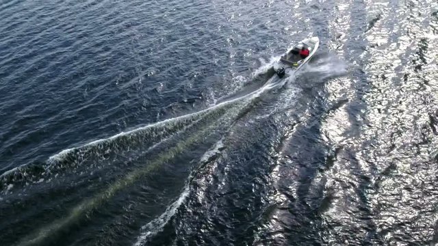Slow motion view of riding water surface speed boat, aerial shot
