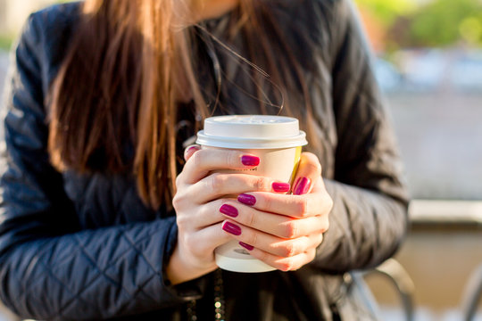 Woman hold cup of coffee on street