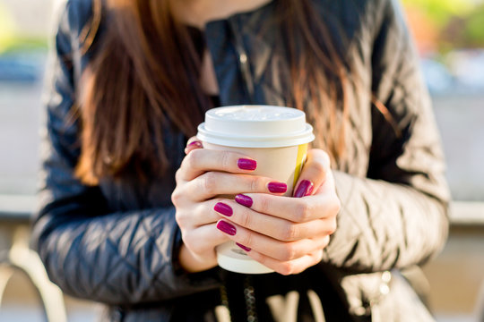 Woman hold cup of coffee on street