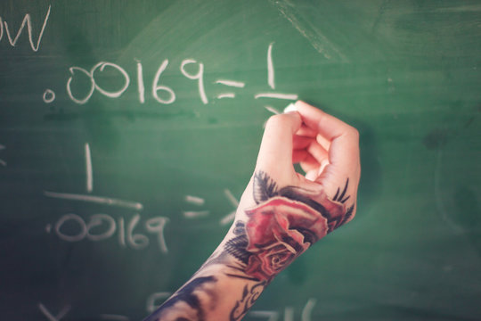 Tattooed hand writing on board