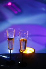 Candlelit champagne glasses beside a jacuzzi