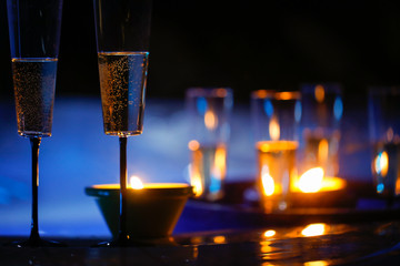 Candlelit champagne glasses beside a jacuzzi - obrazy, fototapety, plakaty