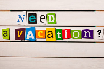 Need a vacation - written with color magazine letter clippings on wooden board