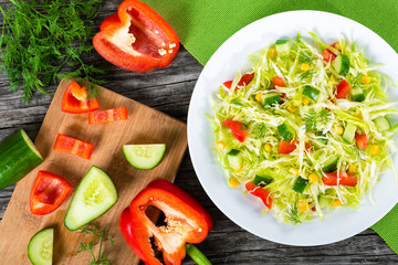 spring cabbage salad with bell pepper, corn, cucumber, top view
