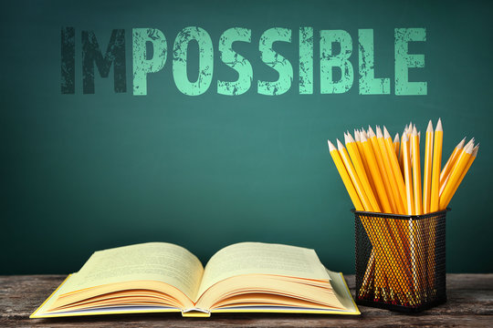 Word impossible transformed into possible on blackboard and school supplies