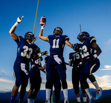 Teenage and young male american football team celebrating