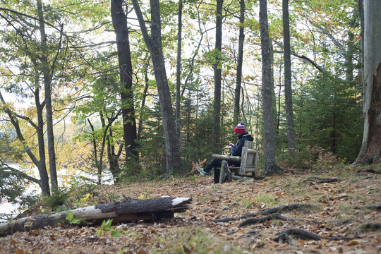 Male hiker sitting on seat in forest, Rangeley, Maine, USA