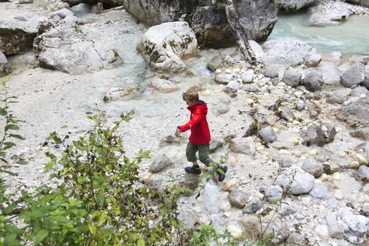 High angle view of boy on rocky river bank, Zauberwald, Bavaria, Germany