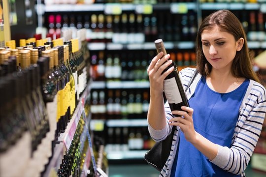 Woman looking at wine bottle