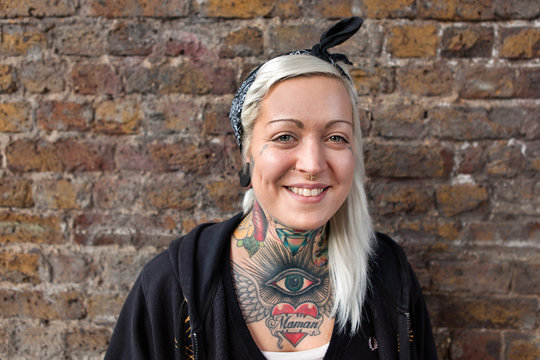 Portrait of young woman with nose ring stud and tattoo