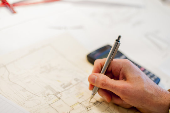 Architect working blueprints, focus on hand