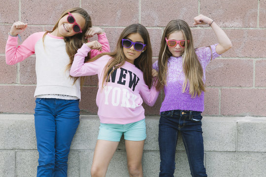 Three girls flexing muscles