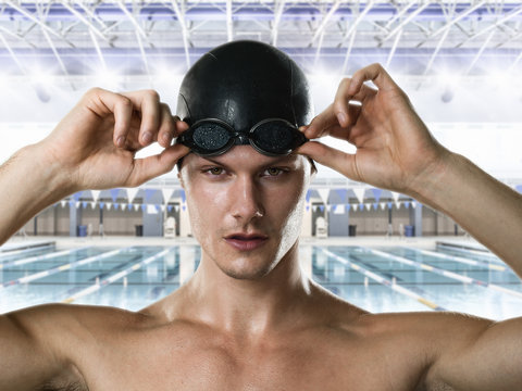 Male swimmer adjusting swimming goggles - Powered by Adobe