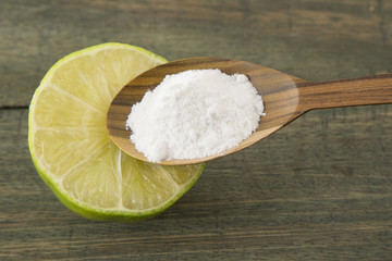 baking soda (sodium bicarbonate) in a wooden spoon and lemon