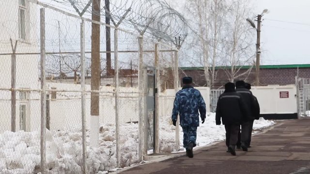 The guard going with prisoners in a jail Russia