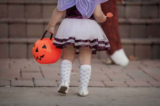 Toddler carrying Jack O' Lantern bucket