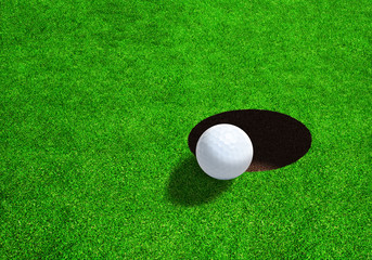 Golf ball on edge of hole with copy space. Low side angle view.