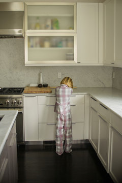 Rear view of boy sulking at kitchen counter