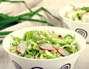 Fresh vegetables salad with cabbage, radishes. dill and greens