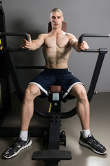 Fototapeta na wymiar Young Man Exercising Chest In The Gym