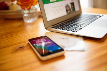 Smartphone and laptop on kitchen table