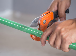 hand of working cutting PPR pipe