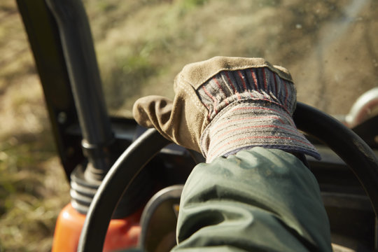 Close up of male hand driving tractor dairy farm field