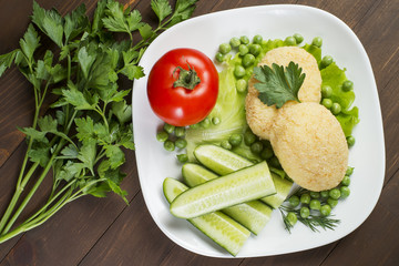 Potato patties with tomato, cucumber, green peas