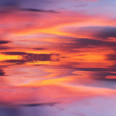 Naklejka na ściany i meble Orange and purple sunset reflected in water