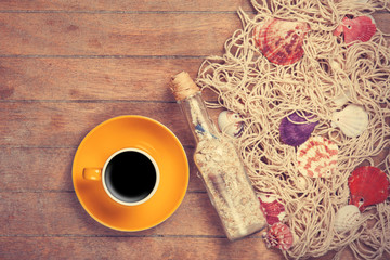 Fototapeta na wymiar Cup and net with shells and bottle