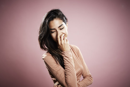 Portrait of young woman, hand touching face, laughing